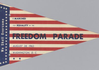 Paper pennant from March on Washington with phrases like "We Shall Overcome" and "I marched for equality in the Freedom Parade"