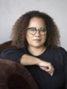 Woman with brown shoulder length hair wearing black shirt