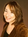 Woman with brown hair wearing a brown blazer