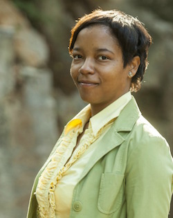 Women with short hair wearing green jacket and yellow shirt